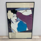 Framed Print of Woman in Aqua Top and Purple Pants by Patrick Nagel